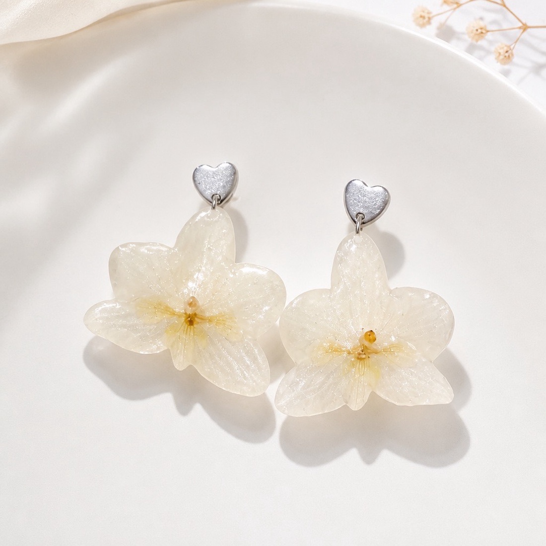 Cercei handmade cu orhidee albă naturală și inimioară din oțel inoxidabil - bijuterii - cercei - cercei din rășină - Artynos.ro