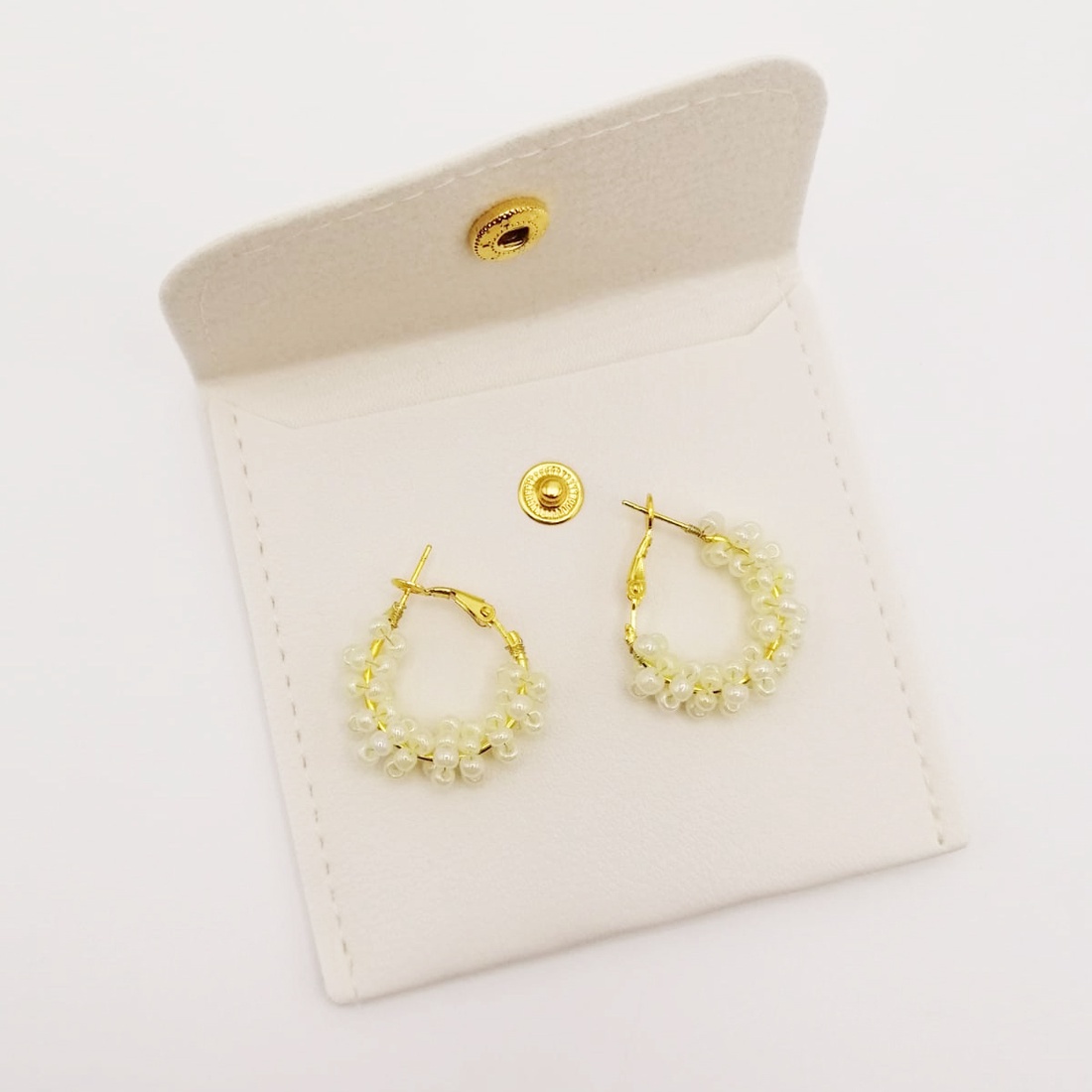 Cercei rotunzi aurii cu pietre albe, cu plic din piele alb - bijuterii - cercei - cercei din mărgele - Artynos.ro