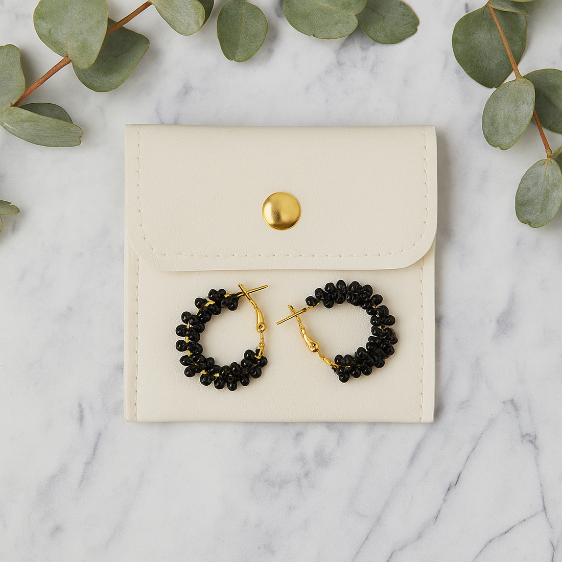 Cercei rotunzi aurii cu pietre negre, cu plic din piele alb - bijuterii - cercei - cercei din mărgele - Artynos.ro