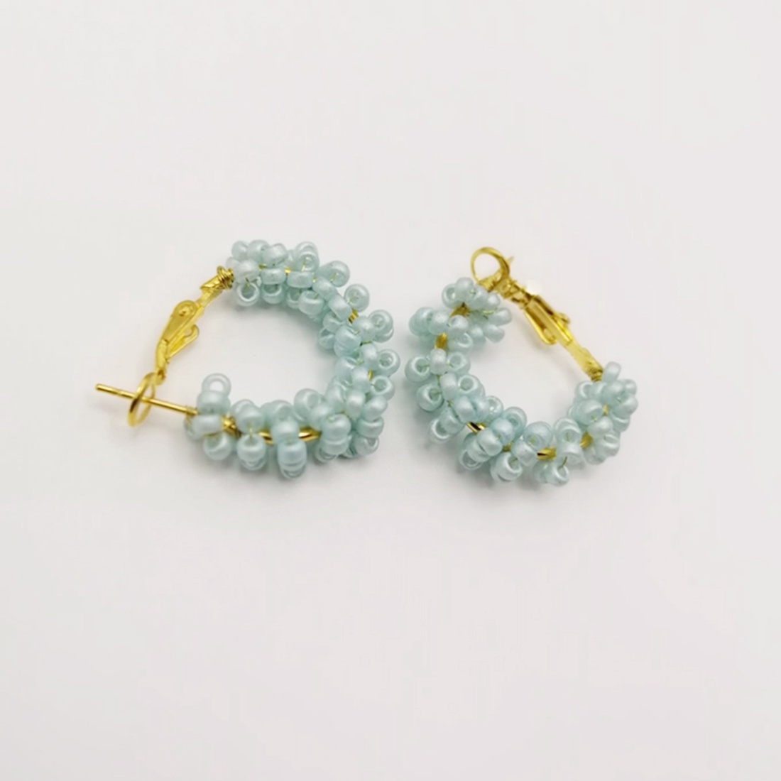 Cercei rotunzi aurii cu pietre albastre, cu plic din piele alb - bijuterii - cercei - cercei din mărgele - Artynos.ro