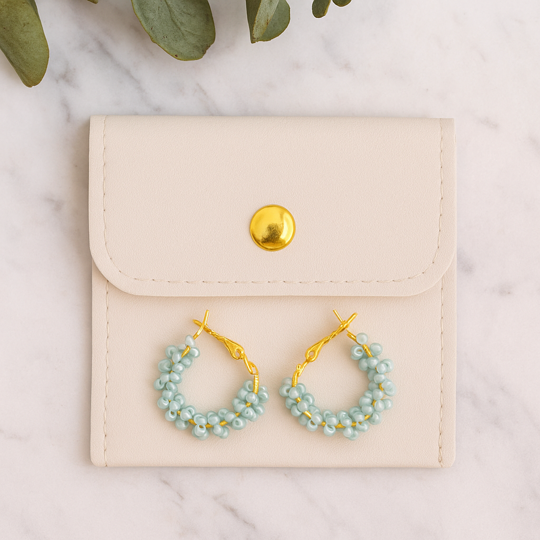 Cercei rotunzi aurii cu pietre albastre, cu plic din piele alb - bijuterii - cercei - cercei din mărgele - Artynos.ro