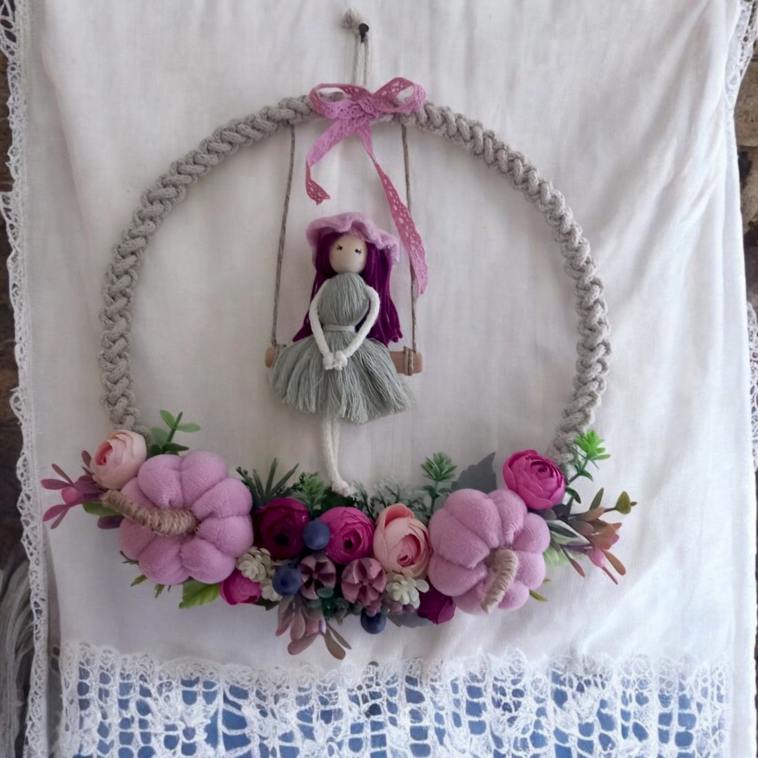 Decorațiune de perete mare din macramé � păpușă balansoar pe un cerc din fire, cu dovleci roz și flori realiste într-o ramă foto -  - Artynos.ro
