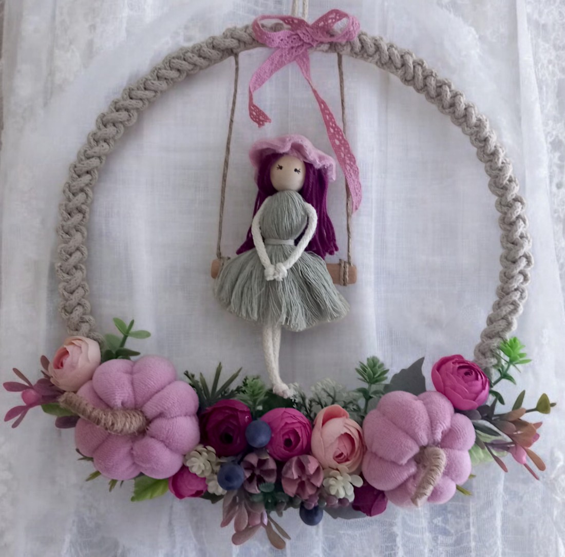 Decorațiune de perete mare din macramé � păpușă balansoar pe un cerc din fire, cu dovleci roz și flori realiste într-o ramă foto -  - Artynos.ro