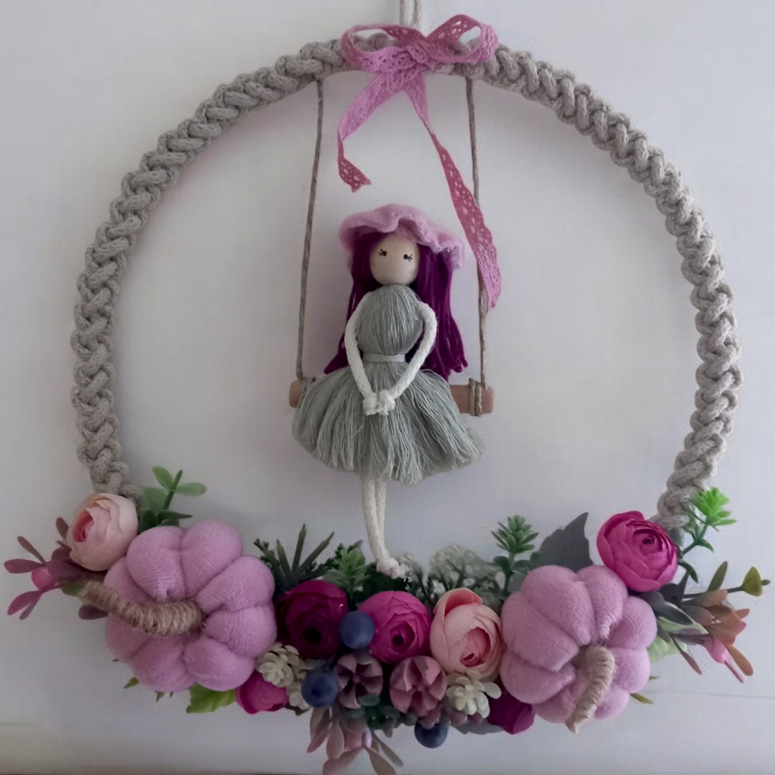 Decorațiune de perete mare din macramé � păpușă balansoar pe un cerc din fire, cu dovleci roz și flori realiste într-o ramă foto -  - Artynos.ro