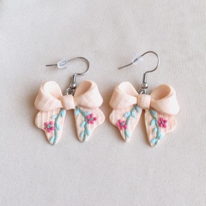 Cercei fundiță din lut polimeric, textură brodată � culoarea piersicii  - bijuterii - cercei - cercei cu figurine - Artynos.ro
