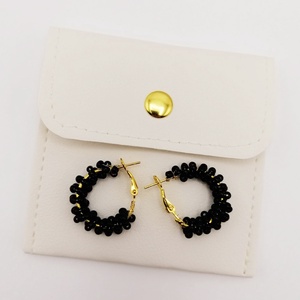 Cercei rotunzi aurii cu pietre negre, cu plic din piele alb - bijuterii - cercei - cercei din mărgele - Artynos.ro