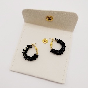 Cercei rotunzi aurii cu pietre negre, cu plic din piele alb - bijuterii - cercei - cercei din mărgele - Artynos.ro