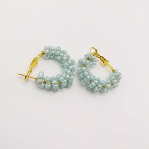 Cercei rotunzi aurii cu pietre albastre, cu plic din piele alb - Artynos.ro