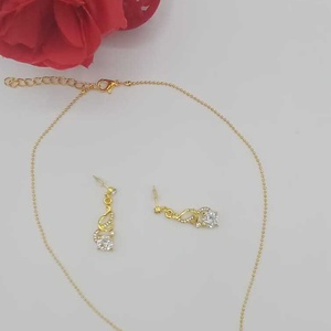 Set delicat de bijuterii format din colier și cercei asortați, realizat din elemente metalice cu finisaj auriu. - bijuterii - coliere - pandative - Artynos.ro